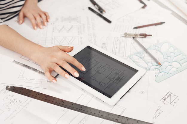 Détail d'une architecte consultant des designs d'appartements sur tablette Architecte féminine sur tablette consultant des exemples de design